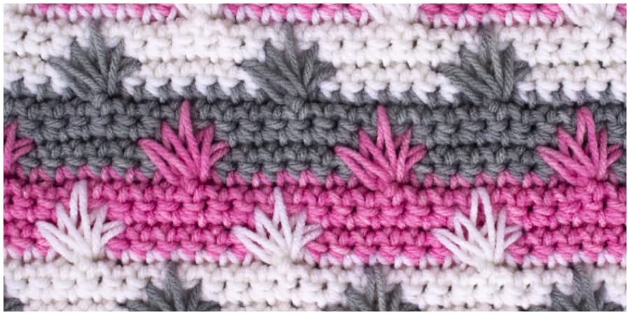 This is a crochet spike stitch that you make into clusters. It's a very simple pattern consisting of single crochet stitches and elongated stitches; the only trick is knowing where to put the spike stitches. 
